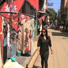 Återresa Nepal, Karin utanför butik med nepalesiska flaggor